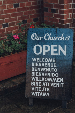 Rye, UK - October 10, 2020: Close up of open sign outside St Anthony of Padua Church, a Roman Catholic Parish church in Rye, one of the best-preserved medieval towns in East Sussex, England.のeditorial素材