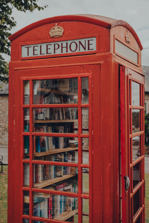 Combe St Nicholas, UK - July 25, 2020: Book exchange inside red phone box in Combe St Nicholas, a village in Somerset, on the edge of the Blackdown Hills Area of Outstanding Natural Beauty.のeditorial素材