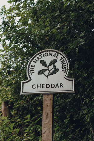 Cheddar, UK - July 26, 2020: The National Trust sign at the entrance to Cheddar, a village famous for its Gorge and is the birthplace of world famous cheese.のeditorial素材