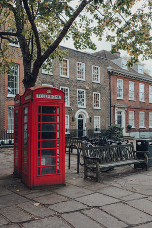 London, UK - October 10, 2020: Red phone boxes on Richmond Green in Richmond. Red phone boxes can be found in current or former British colonies around the world.のeditorial素材