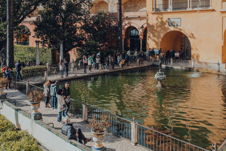 Seville, Spain - January 19, 2020: Tourists by the Mercury Pond next to Grutescos Gallery in Alcazar of Seville, a Royal palace built for the Christian King Peter of Castile.のeditorial素材