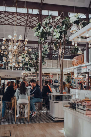 Seville, Spain - January 19, 2020: People at the tables in Lonja del Barranco, gourmet marked housed in a 19th-century building created as a fish market.のeditorial素材