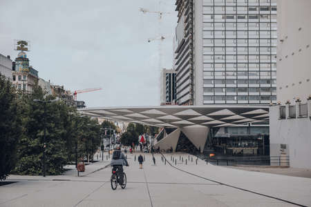 Brussels, Belgium - August 16, 2019: Rear view of a man cycling on a street in Brussels, the largest municipality and historical centre of the Brussels-Capital Region.のeditorial素材