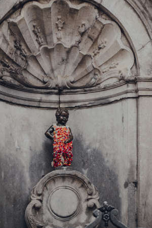 Brussels, Belgium - August 16, 2019: View of Manneken pis, a landmark 61 cm bronze fountain sculpture in central Brussels, depicting a naked little boy urinating into the fountain's basin.のeditorial素材