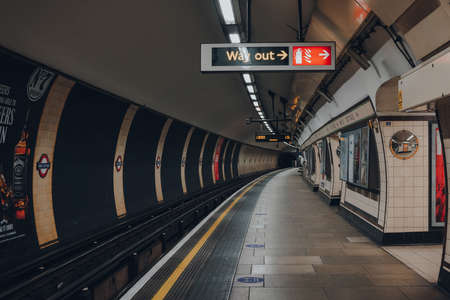 London, UK - May 09, 2021: Way out sign on an empty platform of London Underground, the oldest underground railway in the world, selective focus.のeditorial素材