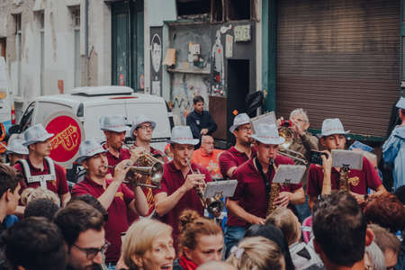 Brussels, Belgium - August 17, 2019: Band performing for a crowd of people on a narrow street in old...