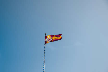 Ana Mera, Greece - September 24, 2019: Low angle view of a flag on Panagia Tourliani Monastery, a whitewashed church and monastery on Mykonos dating from the 16th century.のeditorial素材