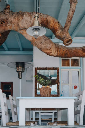 Tables at an outdoor terrace of a restaurant in Mykonos, Greece, selective focus, natural light, no people.の写真素材
