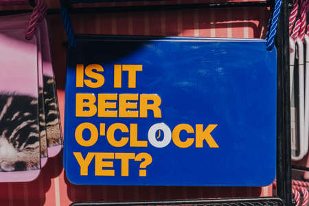 Close up of Is it beer o'clock yet funny blue and yellow sign.