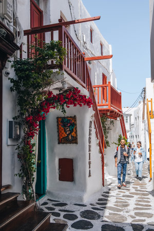 Mykonos Town, Greece - September 23, 2019: People walking traditional buildings on a narrow street in Hora (also known as Mykonos Town), the islands well-preserved port and capital.のeditorial素材