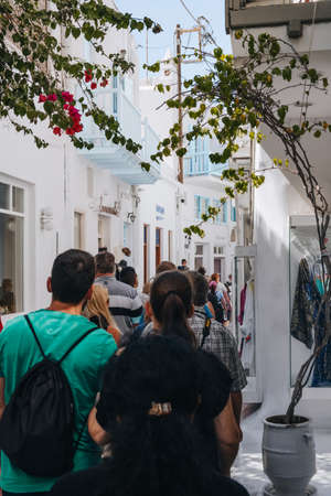 Mykonos Town, Greece - September 24, 2019: View of a busy narrow street in Hora (also known as Mykonos Town), the islands well-preserved port and capital, over tourists walking, selective focus.のeditorial素材