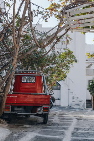 Mykonos Town, Greece - September 24, 2019: Rear view of a red Piaggio Ape car parked on a street in Hora (also known as Mykonos Town), the islands well-preserved port and capital.のeditorial素材