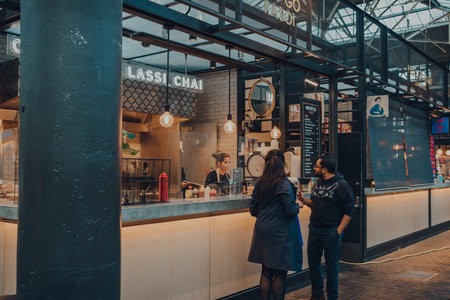 London, UK - September 03, 2021: People at at Indi-Go street food stall in Spitalfields Market, one of the finest surviving Victorian Market Halls in London with stalls offering fashion and food.のeditorial素材
