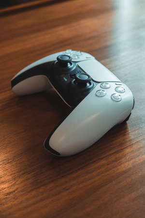 London, UK - May 25, 2021: Side view of Playstation 5 (PS5) controller on a table. Playstation 5 is the latest video game console by Sony released in November 2020 as a successor to the PlayStation 4のeditorial素材
