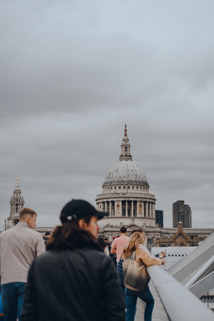 London, UK - October 23, 2021: View of St. Pauls Cathedral, the cathedral of the Bishop of London, over the people walking on Millennium Bridge, selective focus.のeditorial素材