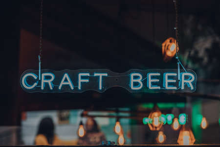 Neon craft beer sign at the window of a pub in London, UK, selective focus.の写真素材
