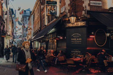London, UK - June 13, 2020: People at the outdoor tables of Shakespeares Head pub in Soho, an area of Central London famous for its pubs and restaurants. People walking past, selective focus.のeditorial素材