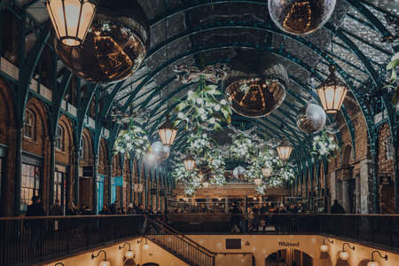 London, UK - November 23, 2021: Christmas decorations, mistletoe and giant festive baubles in Covent Garden Market, one of the most popular tourist sites in London.のeditorial素材