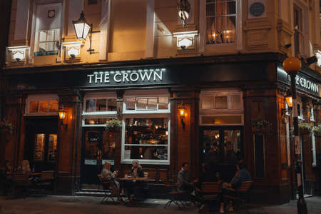 London, UK - November 23, 2021: People sitting at the outdoor tables of The Crown pub on Seven Dials in Covent Garden, one of the most popular tourist areas in London, UK.のeditorial素材