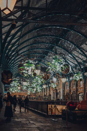 London, UK - November 23, 2021: Christmas decorations, mistletoe and giant festive baubles in Covent Garden Market, one of the most popular tourist sites in London.のeditorial素材