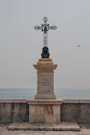 Nice, France - March 11, 2022: Crucifix monument with inscription In Memoriam Jubilaei 1829 et Pacis 1871 on the Promenade des Anglais in Nice, a famous tourist destination on the French Riviera.のeditorial素材