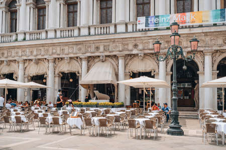 Venice, Italy - May 21, 2022: People at the outdoor tables of Caffe Chioggia in Piazetta San Marco, extension of San Marco square in Venice, capital of Veneto region and a famous travel destination.のeditorial素材