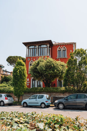 Venice, Italy - May 22, 2022: Row of cars parked in front of a traditional colorful residential building on Lido Island, a barrier island in Venetian Lagoon famous for its Film Festival.のeditorial素材
