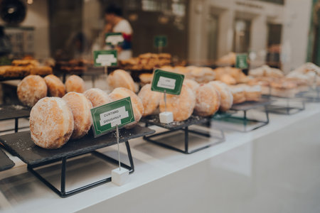 Close of up of a variety of doughnuts on a window display of a cafe in London, UK. Selective focus.の写真素材