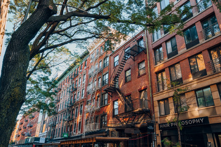 New York, USA - November 21, 2022: Facade of a typical red brick New York apartment block with fire escape in Nolita, a charming and upscale area of Manhattan famous for its shops and restaurants.のeditorial素材