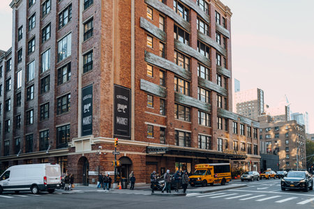 New York, USA - November 21, 2022: People cross 9th Avenue in front of Chelsea Market, a food hall, shopping mall, office building and television production facility located in Chelsea, Manhattan.のeditorial素材