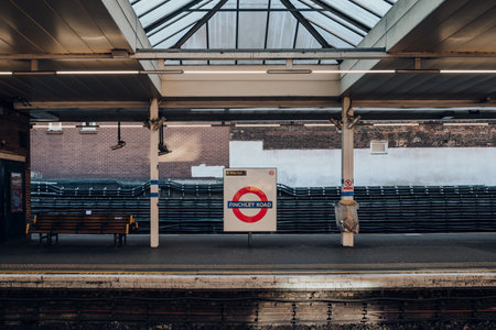 London, UK - December 26, 2022: Roundel name sign at the outdoor platform of Finchley Road station of London Underground, the oldest underground railway in the world.のeditorial素材