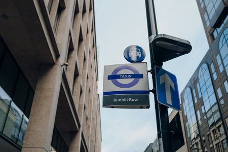 London, UK - February 02, 2023: Low angle view of a Taxi sign at a taxi rank on Bunhill Row in Barbican, an area that is a part of the City of London famous financial district.のeditorial素材