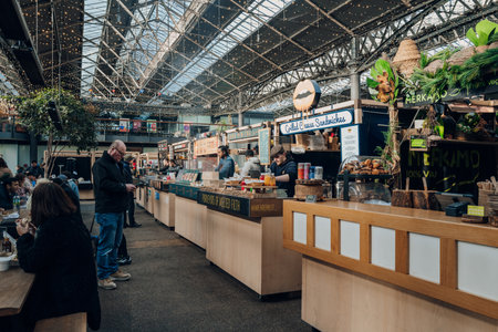 London, UK - February 02, 2023: Row of food market stalls inside Spitalfields Market, one of the finest Victorian Markets in London with stalls offering fashion and food.のeditorial素材