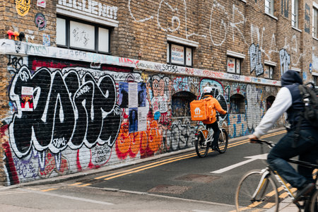 London, UK - February 09, 2023: Just Eat delivery driver on a street in East London. Just Eat is a company that enables food to be delivered from restaurants that do not offer delivery.のeditorial素材
