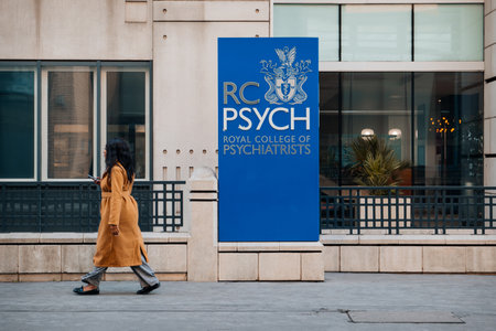 London, UK - February 09, 2023: Sign at the entrance to The Royal College of Psychiatrists, the main professional organisation of psychiatrists in the United Kingdom, woman walking past.のeditorial素材