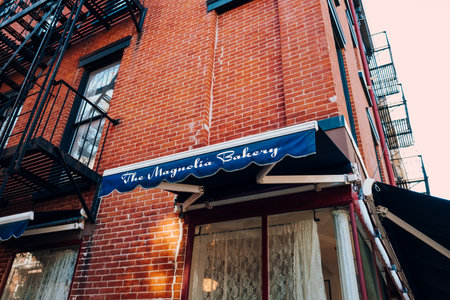 New York, USA - November 21, 2022: Name sign on the canopy of The Magnolia Bakery on Bleecker Street, an original location opened in 1996 that was featured in numerous movies and TV shows.のeditorial素材
