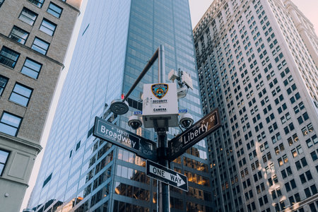 New York, USA - November 25, 2022: NYPD camera above street name signs on the corner of Broadway and Liberty st., one of over 15,000 NYPD surveillance cameras in Manhattan, Brooklyn and the Bronx.のeditorial素材