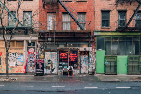 New York, USA - November 25, 2022: Facade of Overthrow Boxing Club on Bleecker Street, one of the most famous streets in the city, man taking a break outside.のeditorial素材