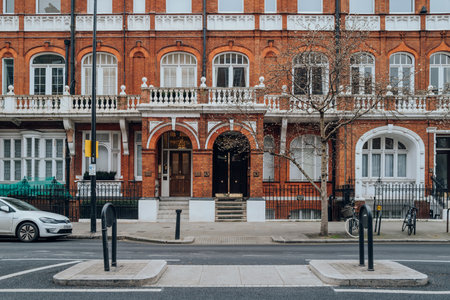 London, UK - February 21, 2023: Exterior or traditional red brick buildings with white window frames in Kensington and Chelsea, an affluent area of West London favoured by celebrities.のeditorial素材