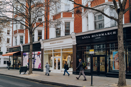 London, UK - February 21, 2023: Row of shops on Sloane Street in Sloane Square, an upscale area of London famous for shopping, culture and dining, people walking past.のeditorial素材