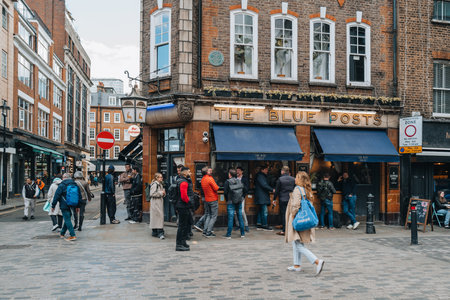 London, UK - April 13, 2023: People walking past The Blue Posts pub in Soho, an area of London famous for LGBTQ+ bars, restaurants and clubs.のeditorial素材