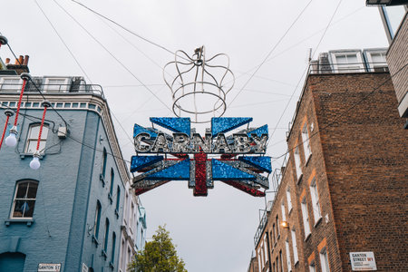 London, UK - April 13, 2023: Large Carnaby and Union Jack 3D sign made of 30,000 red, white and blue shimmer discs with a crown dedicated to coronation of King Charles III on Carnaby Street.のeditorial素材