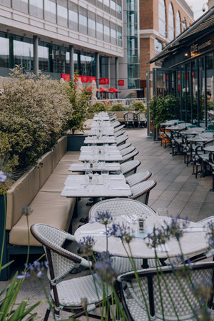 London, UK - July 06, 2023: Outdoor tables of Cote Brasserie restaurant in St Katharine Docks, a former dock and now a mixed-used district and London's only marina in Central London.のeditorial素材