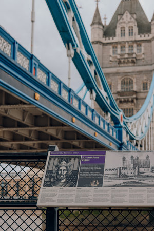 London, UK - July 06, 2023: Sign showcasing the Tower of London history, Tower Bridge on the background. Tower of London and tower Bridge are one of the most popular landmarks in London.のeditorial素材