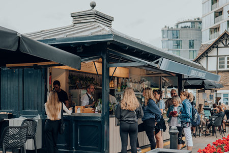 London, UK - July 06, 2023: People buying food and drinks from the cafe on Thames riverside by Tower of London, one of London's top tourist attractions.のeditorial素材