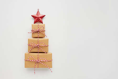 Christmas tree made of gift boxes and decorative star on white background. Top view, flat lay, copy space.の写真素材