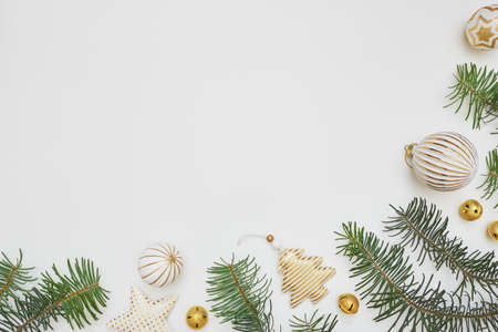 Christmas or New Year composition. Corner border made of fir tree branches and golden decorations on...
