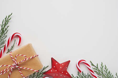 Christmas corner arrangement with gift, conifer branches and decorations on white background