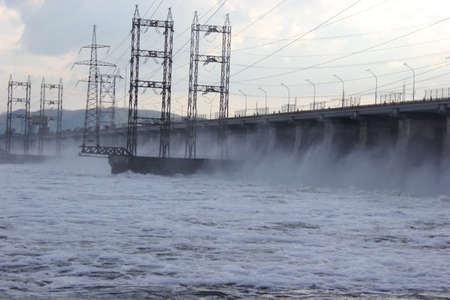 Water falls from the dam industrialists landscape with bridgeの写真素材