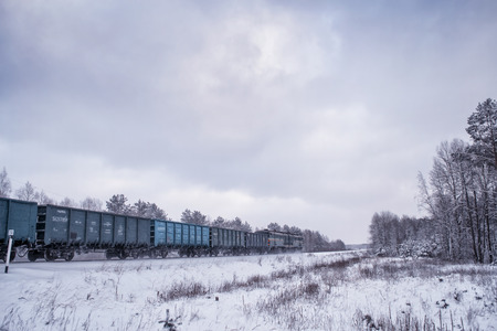 The freight train is traveling through the snow-covered forest in Russia.のeditorial素材